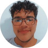 Imagem de um homem jovem, de pele branca mais escura, com cabelo cacheado, que testemunha sobre a sua experiência na Trabbi
